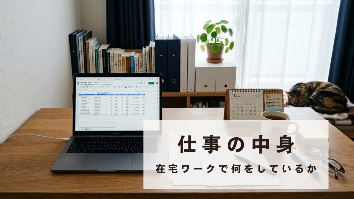 スプレッドシートを表示したノートパソコンと書類が並ぶデスク、奥で丸くなる猫